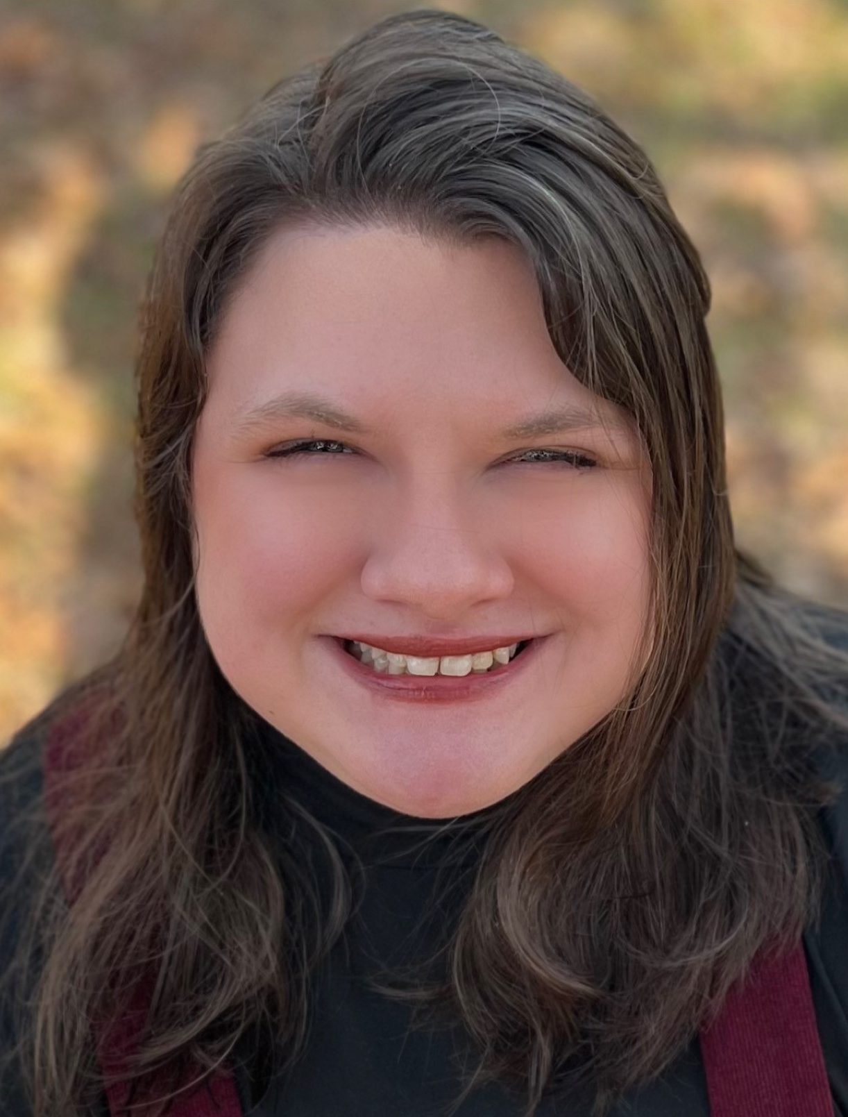 Kara, a smiling white woman with long dark hair.